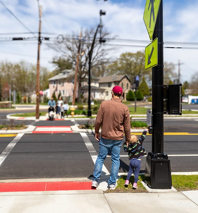 Man standing with child at crosswalk