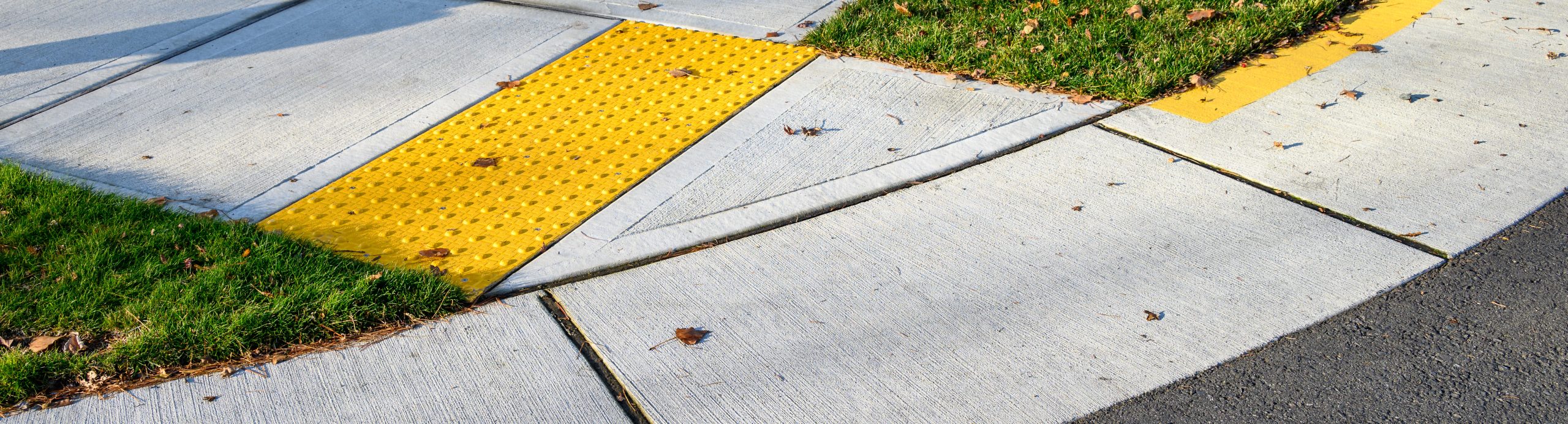 Closeup of a sidewalk with an ADA-accessible curb.