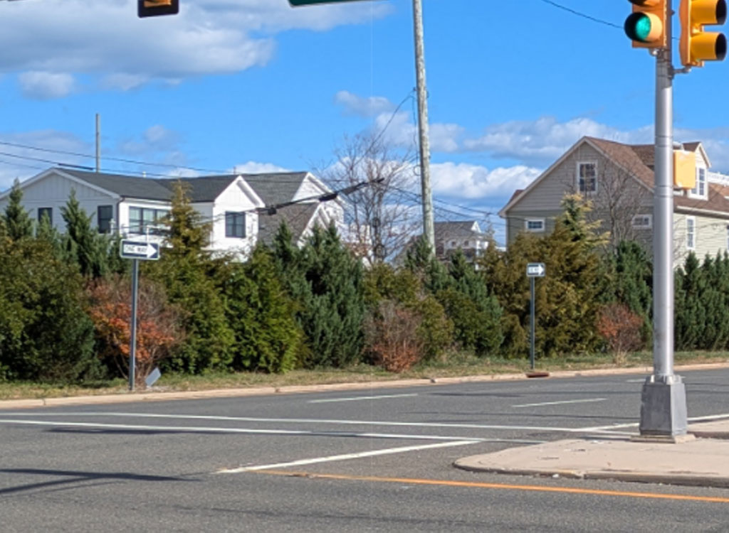 Street-level view of a Route 35 intersection with traffic signals and residential homes in the background